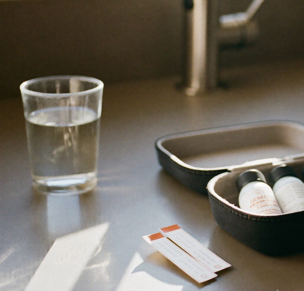 Glass of tap water beside a home water test kit on a Charlotte, NC kitchen counter
